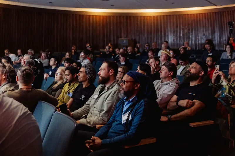A presenter leading a talk in front of a full Film Club audience.