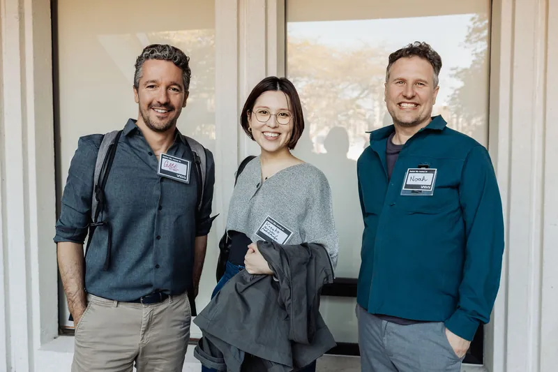 Three attendees gathered near the entrance during the social hour.