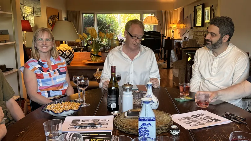 Three people in conversation at the May 5 supper table.