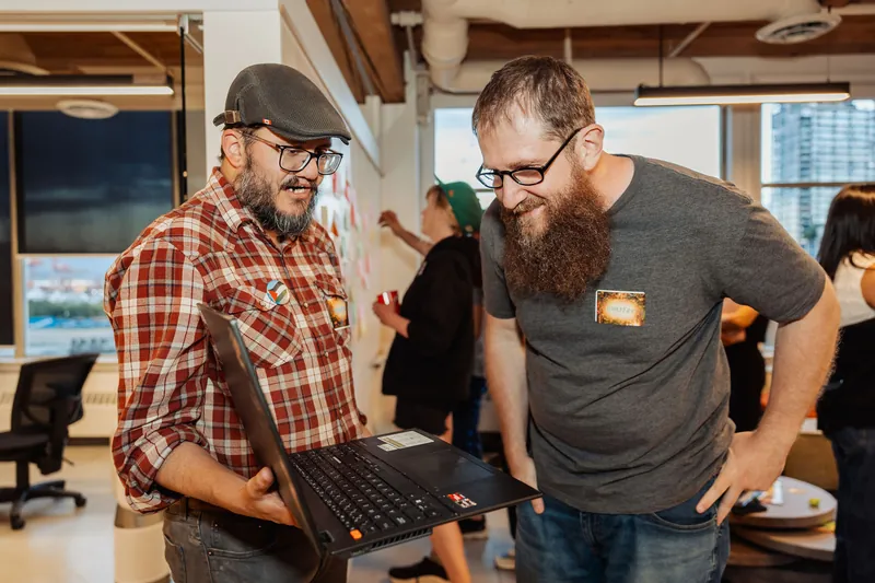 Participants collaborate around a laptop, photo 141.