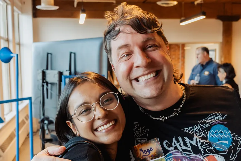 Two attendees share a joyful portrait during the meetup, photo 104.