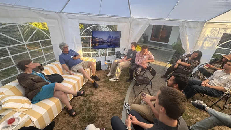 Guests talking on the yellow-and-white striped sofa.