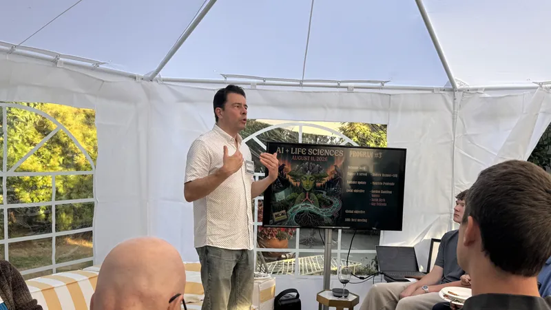 The presentation setup inside the backyard tent, screen and seated guests.