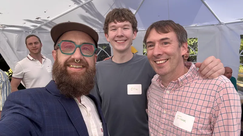 A small group smiling together inside the backyard tent.