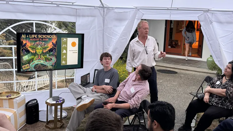 A speaker standing beside the Life Sciences slide in the tent.