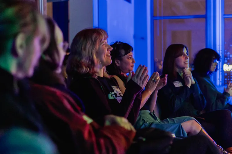 Attendees reacting and applauding during the Film Club program.