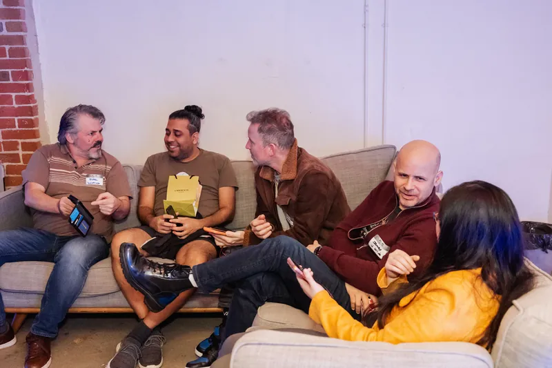A seated discussion circle with hosts and attendees exchanging ideas.