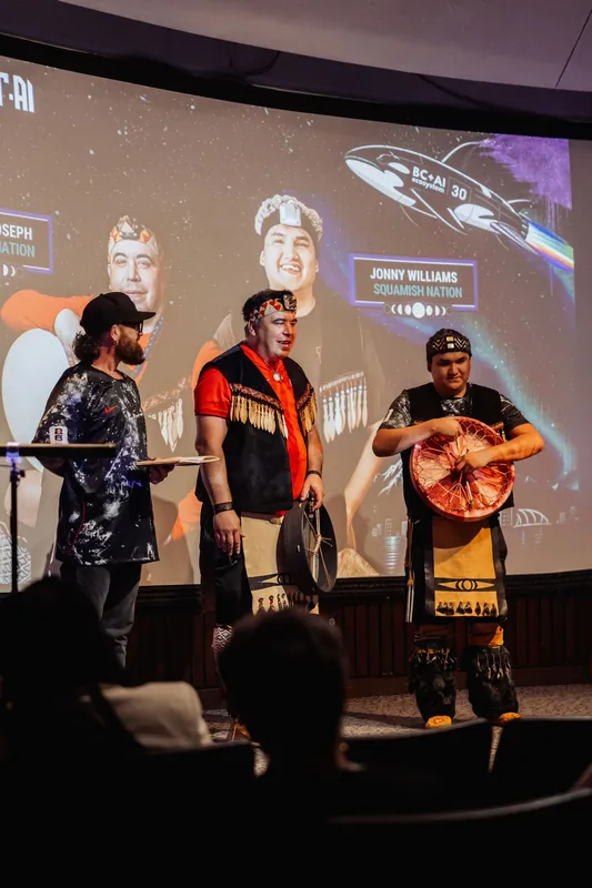 Notes in hand, the host welcomes the two Squamish Nation performers to the Space Centre stage.