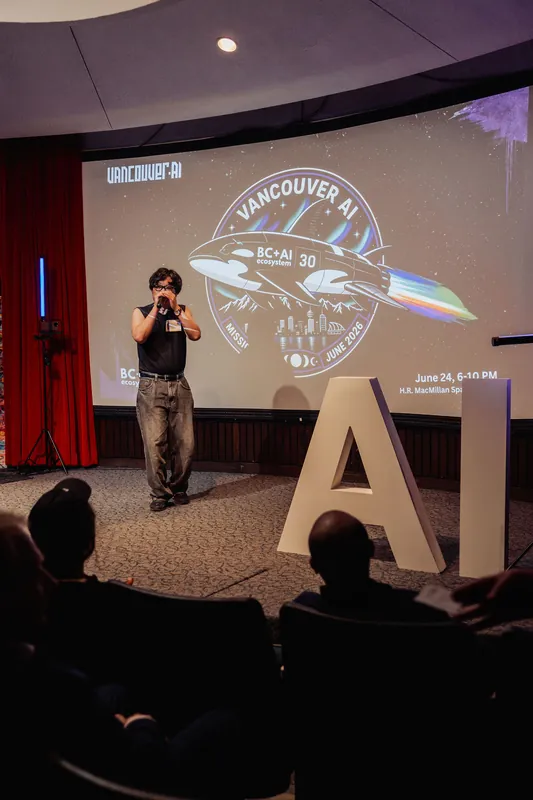 A performer takes the stage at the Space Centre theater, the Vancouver AI Mission 30 badge glowing behind them.