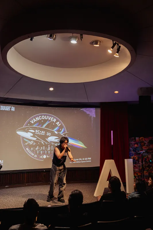 The audience watches attentively as the performer moves through their set beneath the Vancouver AI event branding.