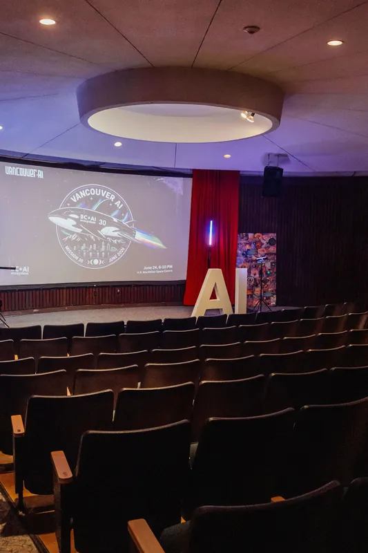 The Space Centre theater sits empty before the program begins, Vancouver AI Meetup #30 logo projected on the main screen.