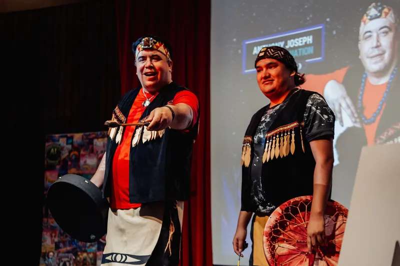 Two Squamish Nation cultural performers open Vancouver AI Meetup #30 with drums on the Space Centre stage.