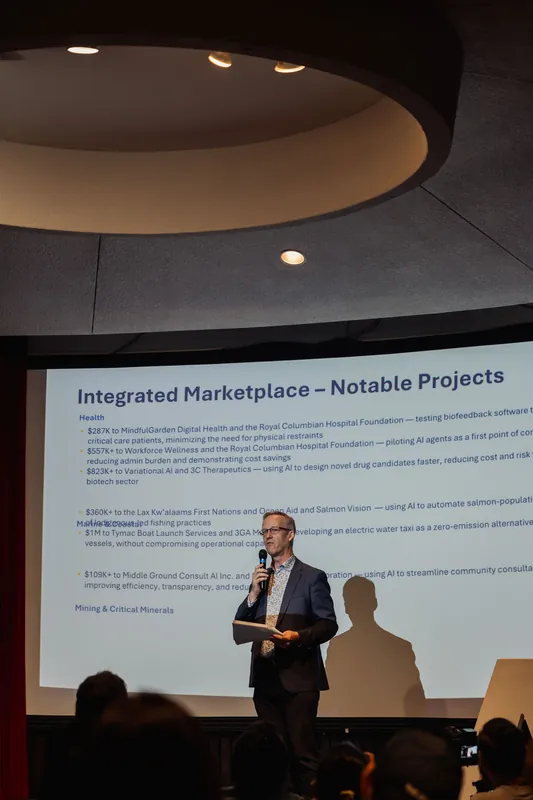 A speaker highlights notable Integrated Marketplace projects across health, marine, and mining sectors.