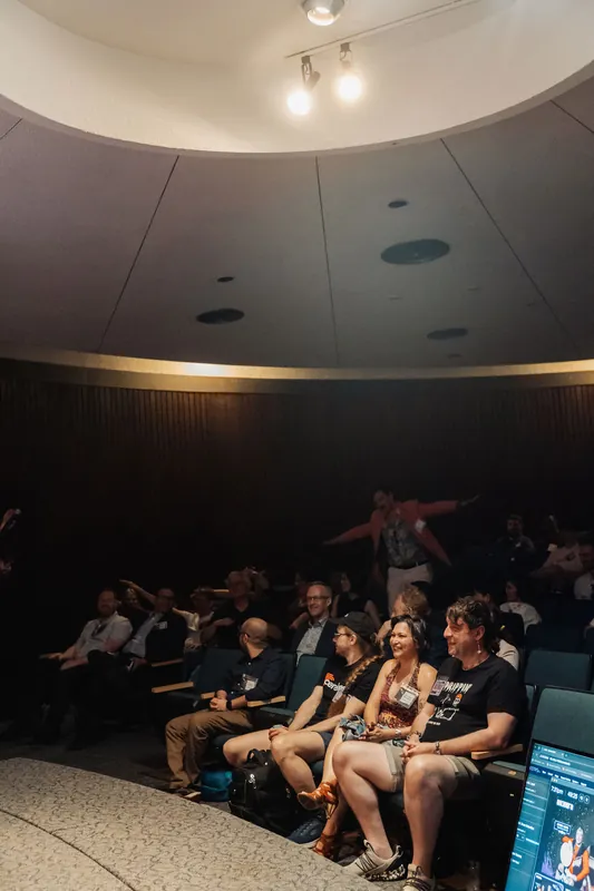 The sweep of the planetarium dome frames rows of smiling attendees watching the program unfold at the Space Centre.