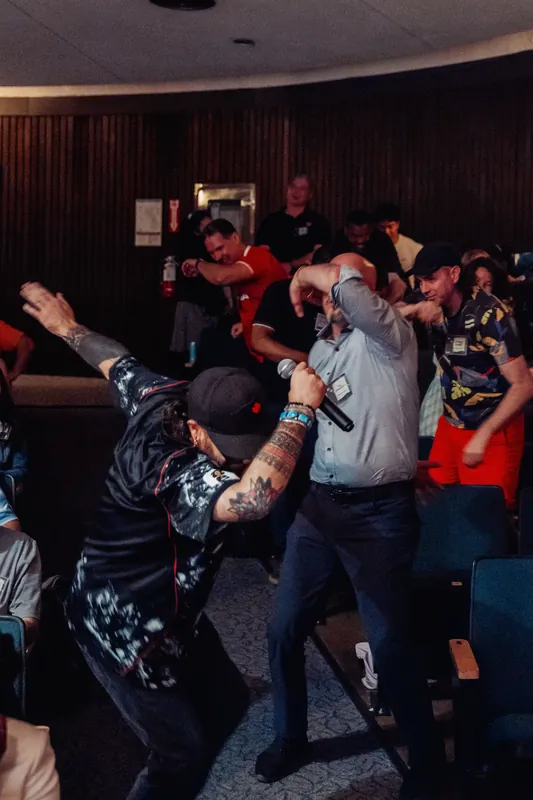 Two attendees launch into an impromptu dance in the Space Centre lounge as the crowd cheers them on.