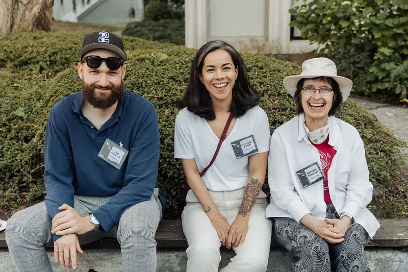 Three attendees share a genuine laugh on the steps outside the Space Centre as the reception fills in.