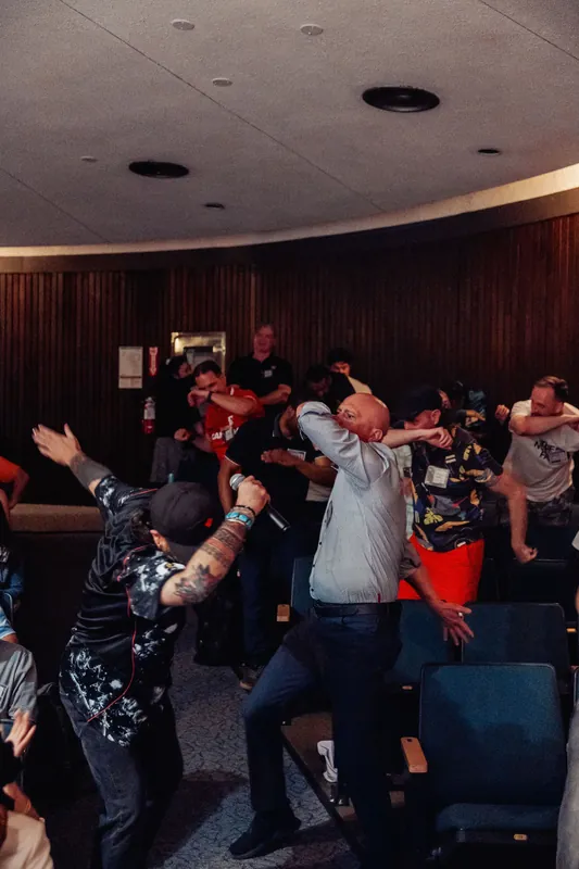 A performer with a microphone leads one final surge of synchronized movement through the delighted Space Centre crowd.