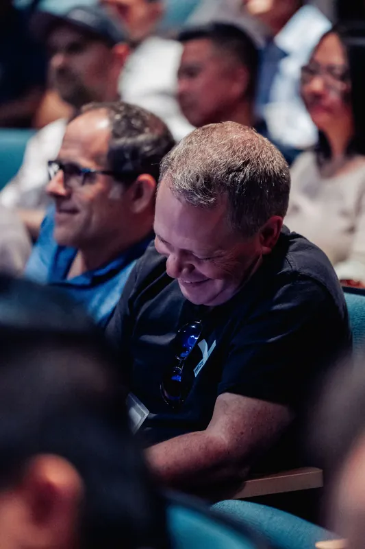 Two attendees share a laugh together during a lively moment in the program.