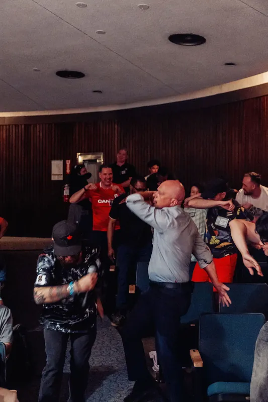 Arms outstretched and heads tucked, participants commit fully to the group movement activity at Meetup #30.