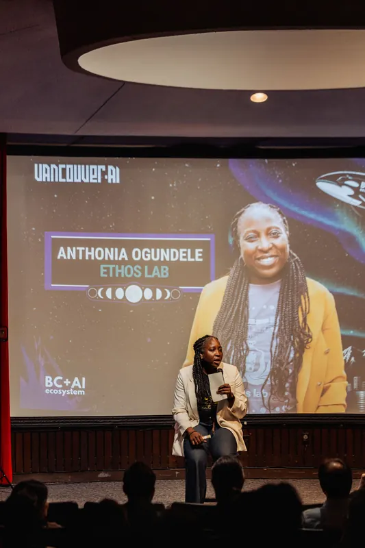 Anthonia Ogundele addresses the seated crowd beneath the planetarium dome, her Ethos Lab introduction filling the screen behind her.