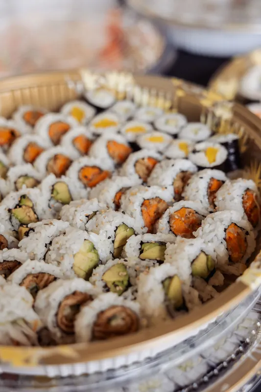 Avocado and salmon rolls fill the frame in a close-up from the reception's sushi buffet.