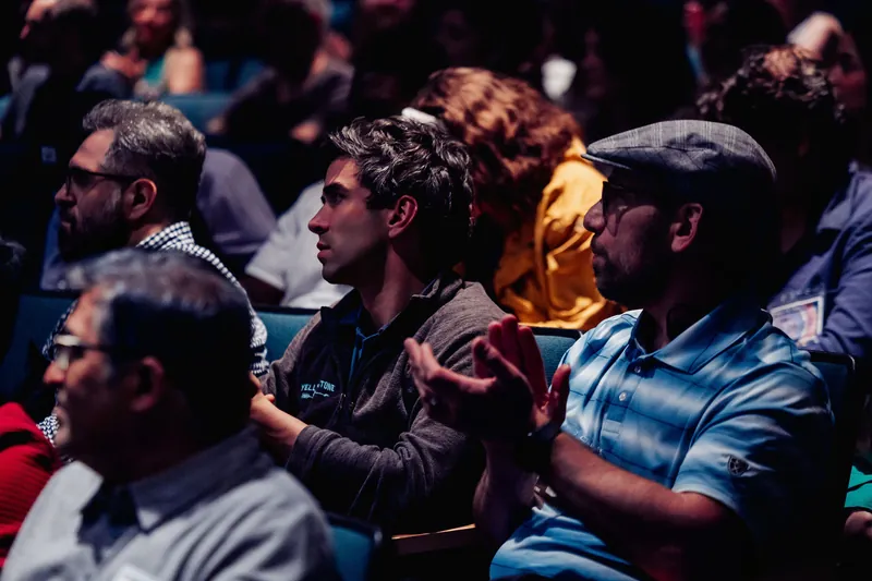 Attendees clap enthusiastically in the theater seats inside the H.R. MacMillan Space Centre planetarium.