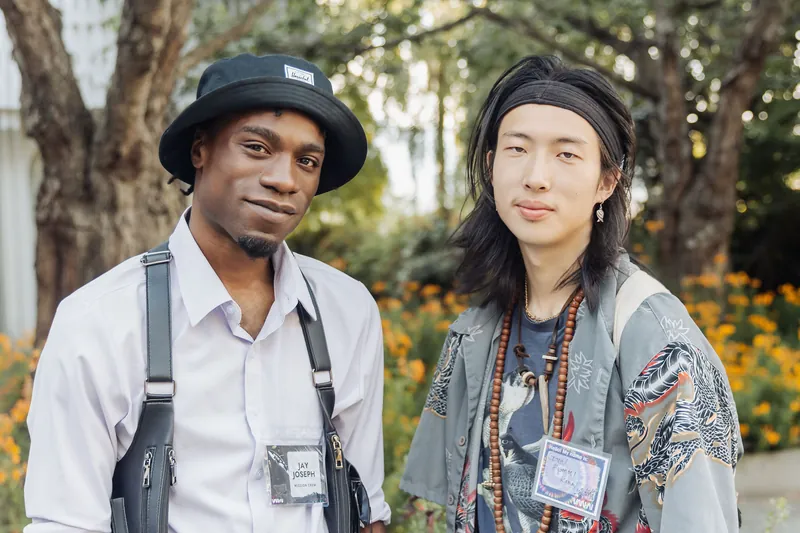 Two attendees with distinctive style — fedora and beads — connect during the outdoor reception at the Space Centre gardens.