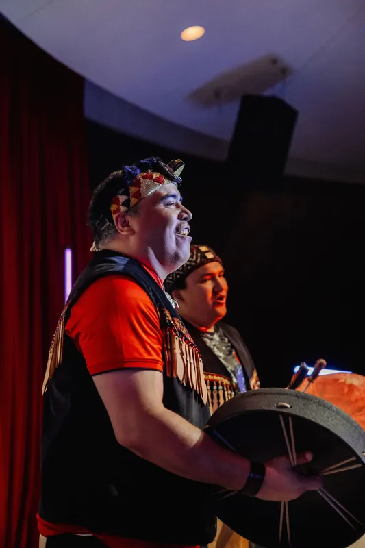 Two Indigenous performers in traditional regalia open the Space Centre program with a ceremonial drum song.