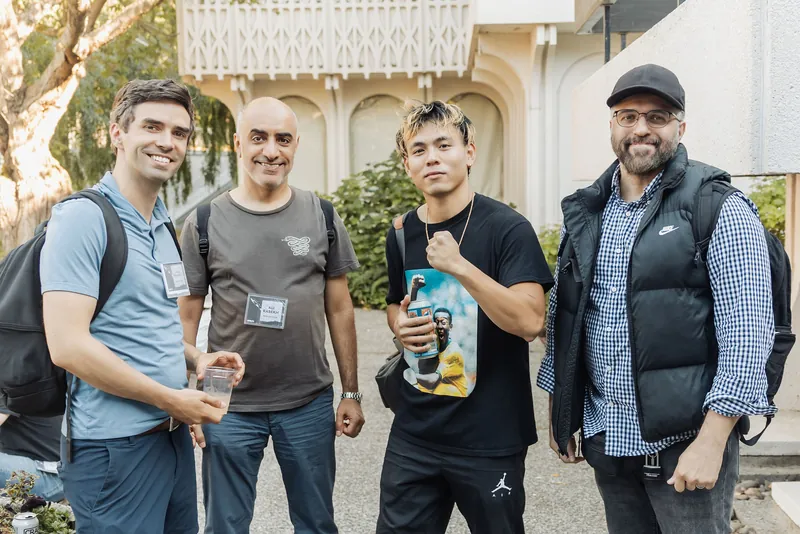 Four attendees gather for a candid photo outside the H.R. MacMillan Space Centre during the pre-program reception.