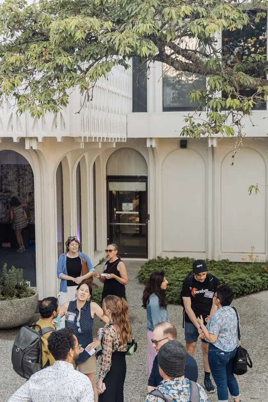The Space Centre's arched white facade frames a courtyard full of guests connecting in the early evening light.