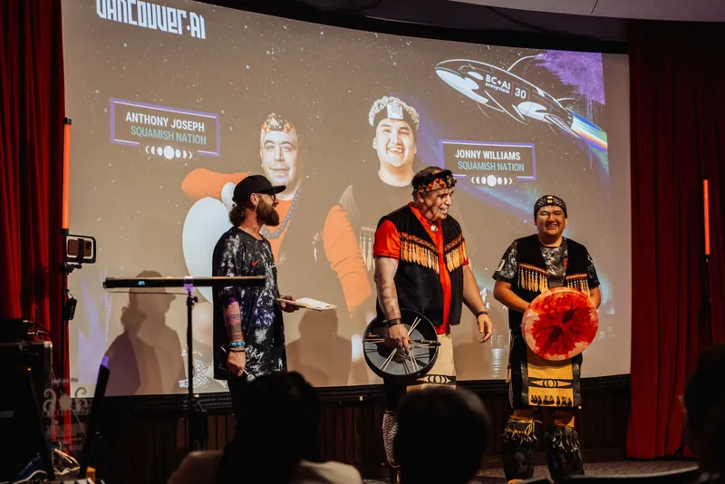 Side-by-side, the host and two Squamish Nation performers take a candid moment before launching into the ceremony.