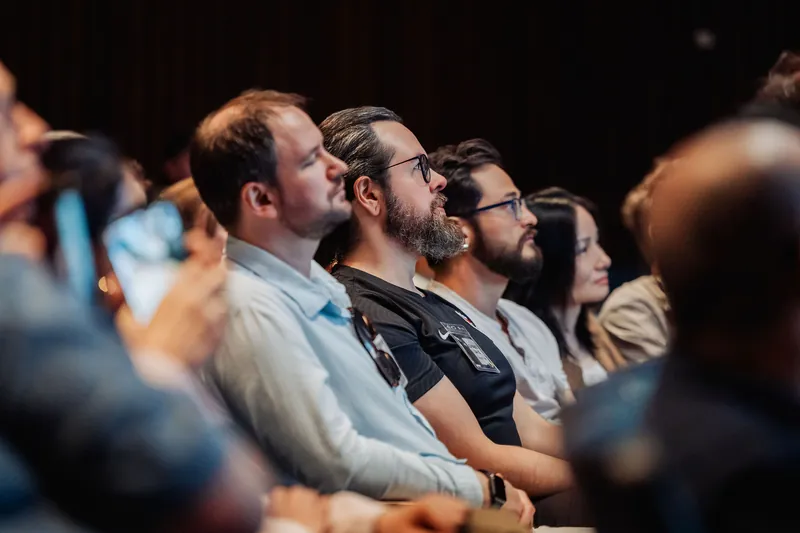 A row of engaged attendees — several with eyes tilted upward — follow a talk inside the Space Centre auditorium.