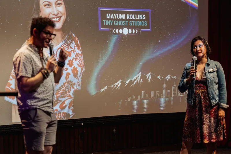 Co-hosts on stage as the 'AI' projection lights the dome.