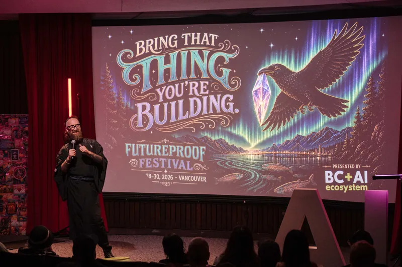 Kris points to Futureproof Festival calls-to-action and QR codes on screen — Wider angle.
