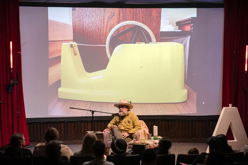Dave Olson's talk opens with archival images and story slides behind him — Screen bright in the background.