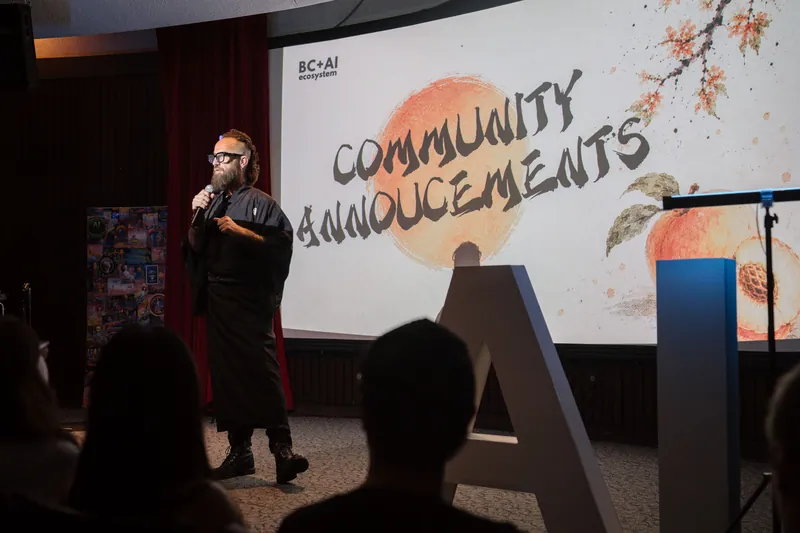Community Announcements open with Kris on stage beside the peach-framed slide.