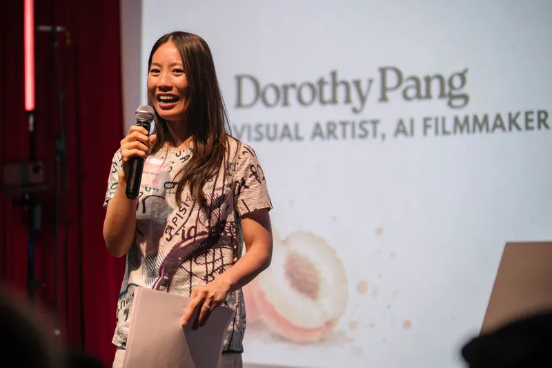 Dorothy Pang holds notes and mic mid-presentation.