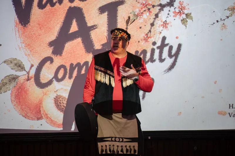An Indigenous welcome unfolds on stage as the audience settles in.
