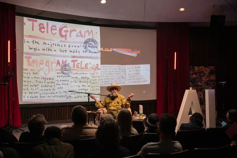 Dave Olson leans into storytelling — clippings, collages, and handwritten notes on screen — A beat later in the same beat.