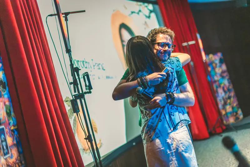 Kevin Friel embraces Dorothy Pang after introducing her to the stage.