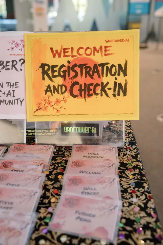 Registration and check-in tables fill with name badges as guests arrive outdoors — Wider angle.