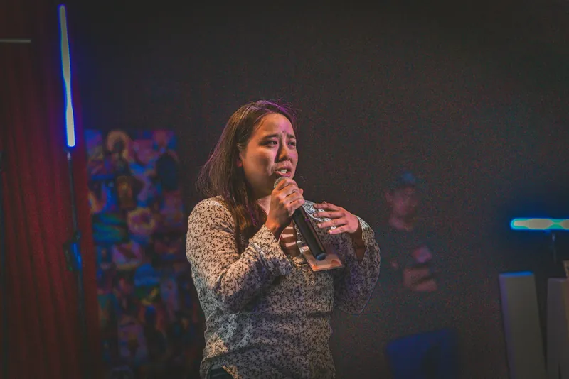 A community member takes the mic during announcements.