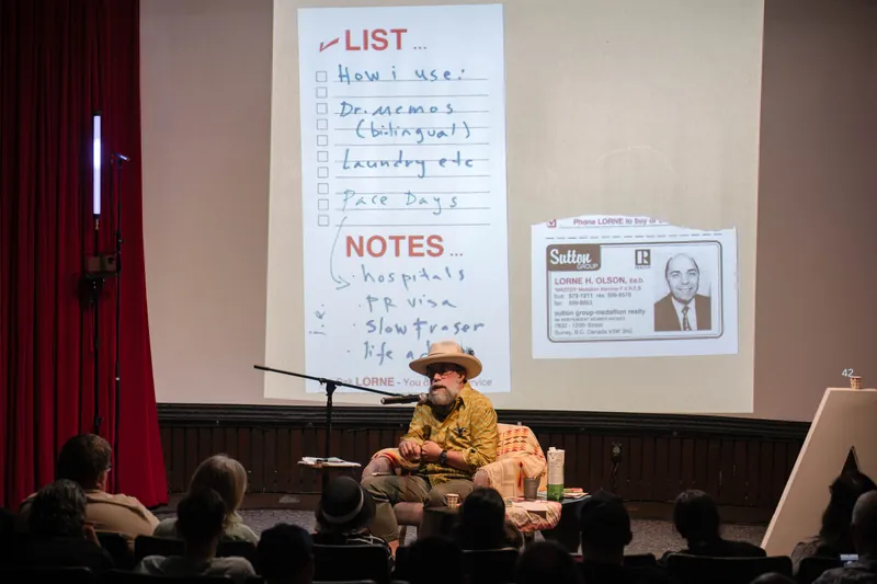 Dave Olson continues from the armchair as denser text and photo slides roll — A beat later in the same beat.
