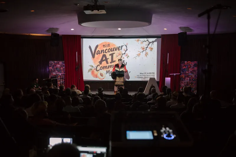 An Indigenous welcome unfolds on stage as the audience settles in — Stage-right view.