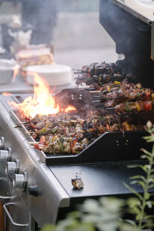 Skewers char over open flames on the outdoor grill before the talks begin.