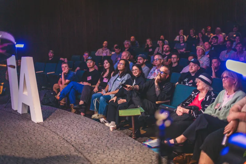 The audience settles in as the program continues.
