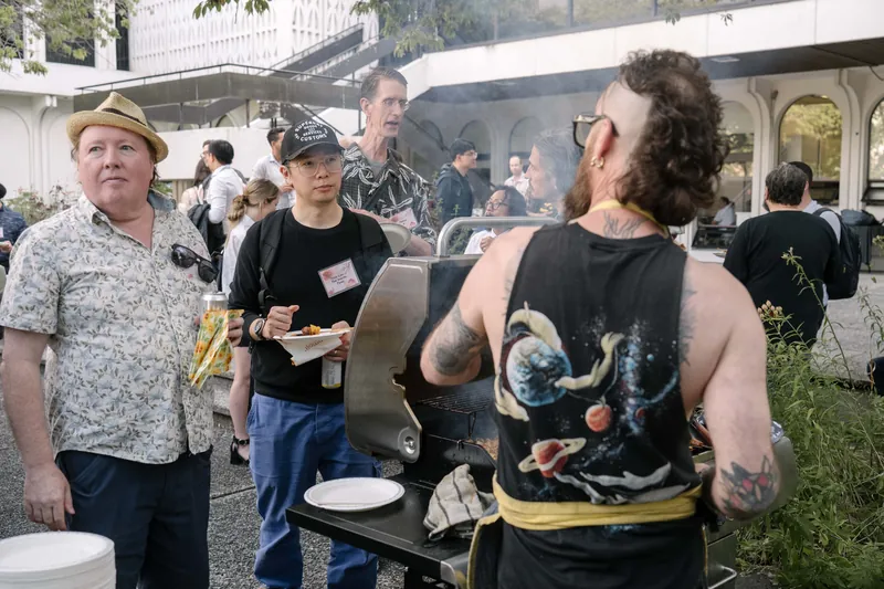 Candid conversations spill across the outdoor mixer before the program starts — From the aisle.