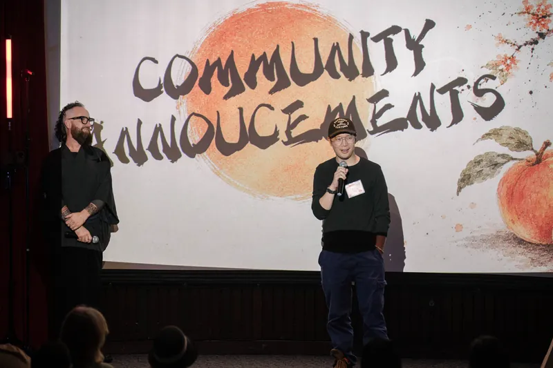 More community announcements roll on — mic handoffs and short stage spots — From the aisle.