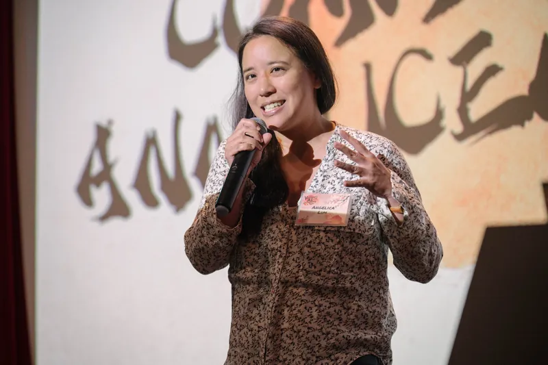 A community announcer shares updates from center stage — Wider angle.