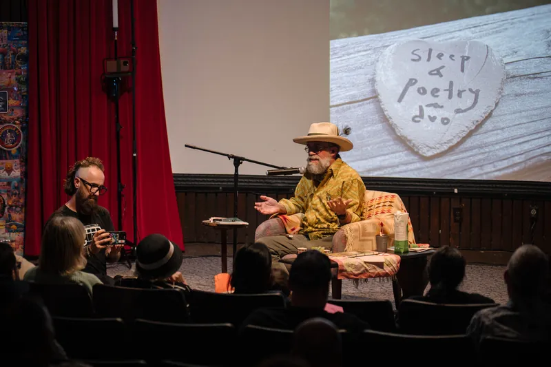 A "Life of a Poet" heart logo glows behind the on-stage conversation.